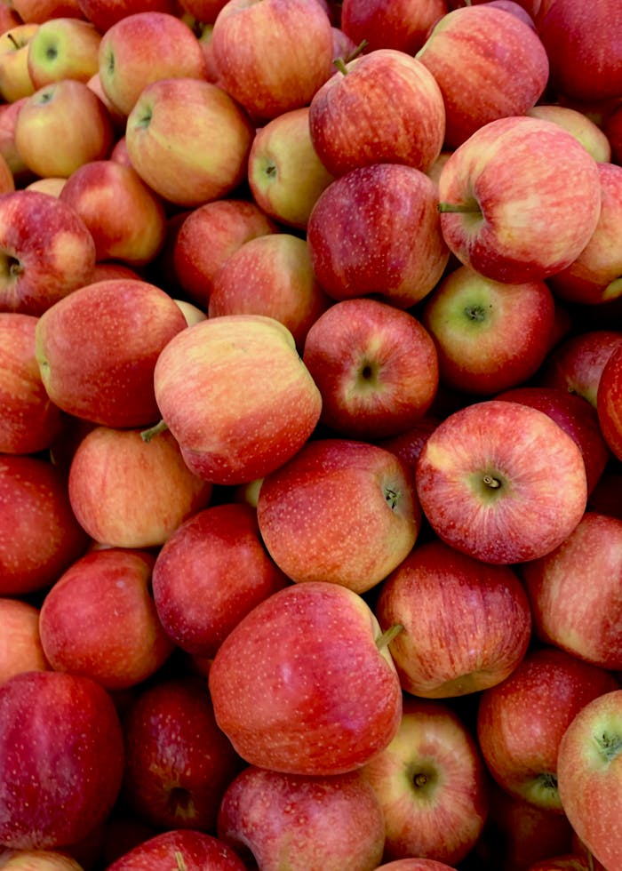 A vibrant pile of fresh, organic red apples showcasing their natural, delicious appeal.